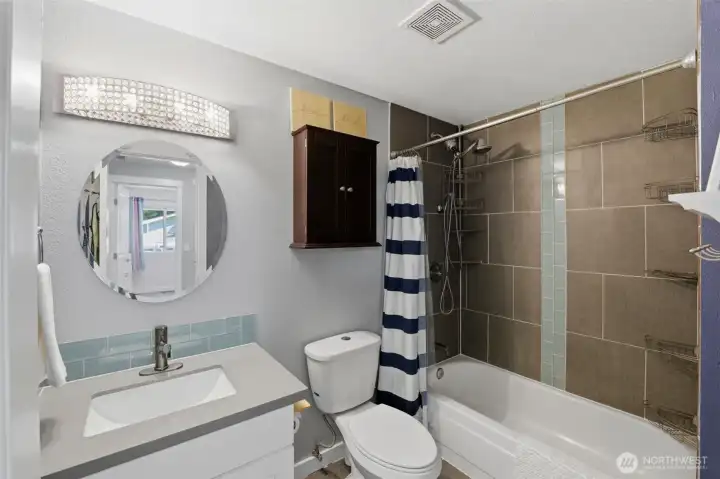 Upstairs hall bath with tiled bath/shower and recent vanity.
