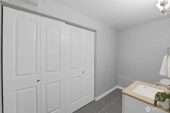 Concealed laundry closet in lower level half bath.