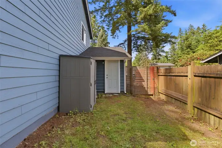 Exterior door to garage and space for the small storage shed on the opposite side yard.