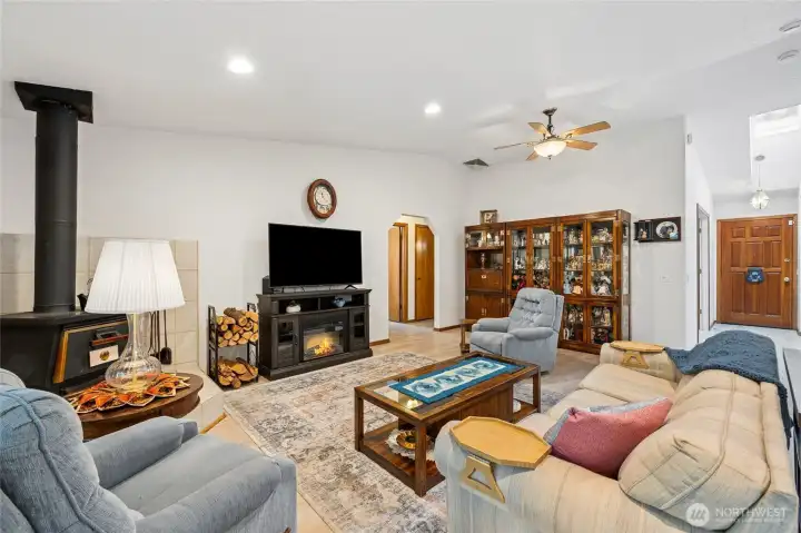 The vaulted living area offers an open flow for everyday living and entertaining, centered around a cozy wood-burning fireplace.