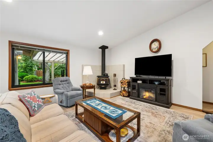Large windows overlook the covered patio and manicured lawn, bringing in abundant natural light.