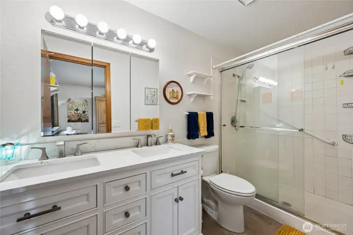 Updated primary bath with a walk-in shower and modern finishes.