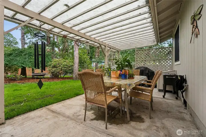 Covered patio overlooking the lawn, complete with sprinkler system, storage shed, and garden space.