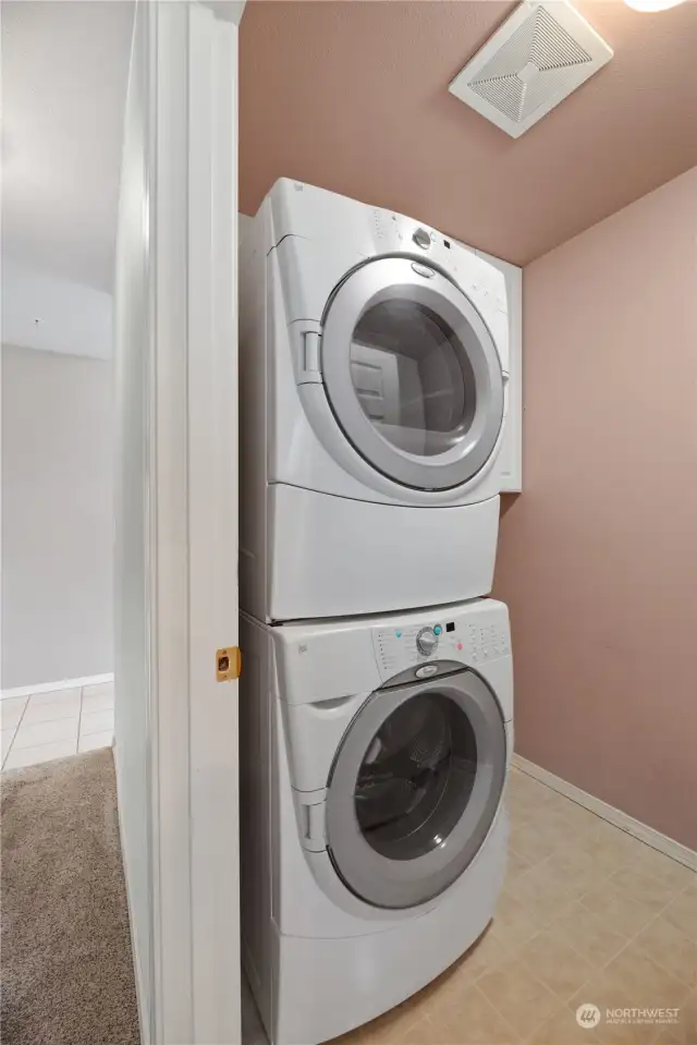 Separate laundry room has a utility sink and storage cabinets.
