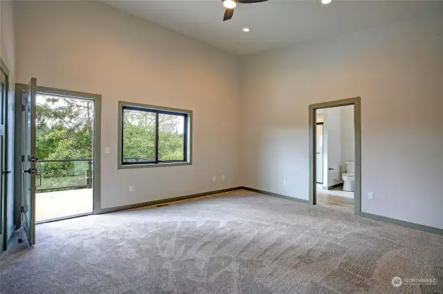 Primary bedroom with access to upper level deck for peaceful lake views.