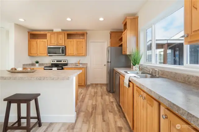 Recessed lighting and high ceilings throughout kitchen and living space