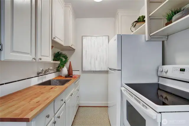 Sweet kitchen with new butcher block countertop, tile and new refrigerator.