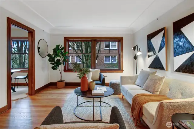 Beautiful living room view from unit entry foyer. Refinished hardwoods, fresh paint, coved ceiling and mahogany trim.