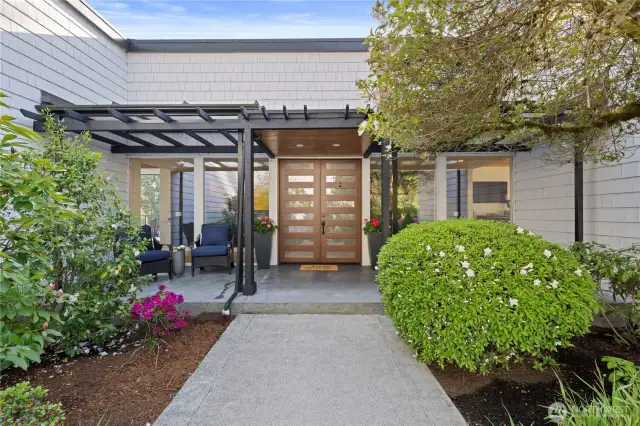 Popping with colorful flowers and accented with landscape lighting, you'll enjoy this courtyard entrance day or night.
