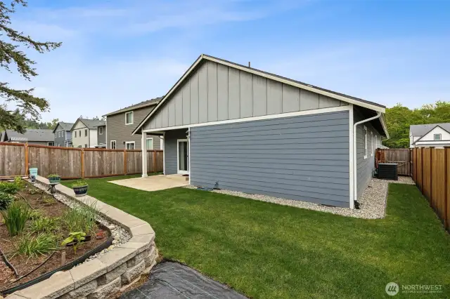Custom landscaping with rock perimeter and sealed fence line