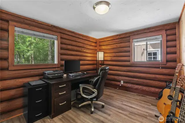 Rustic Home Office with Log Cabin Charm & Woodland Views  Perfect for remote work, music, or creativity, this dedicated home office space features rich log cabin walls, dual windows for natural light & peaceful forest views. With durable flooring & a functional layout, it’s ideal for focused productivity while staying connected to the tranquil surroundings. Whether used as a work-from-home setup or personal studio, this space offers warmth, character & flexibility in your private Pacific Northwest retreat.