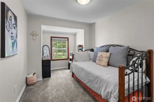 Charming Secondary Bedroom with Peaceful Garden Views  This cozy bedroom features plush carpeting, neutral walls, & a picture-perfect window nook overlooking the lush green landscape. Whether used as a guest room, nursery, or creative space, this room offers a peaceful retreat with plenty of natural light. Decorative touches & versatile layout make it both functional & inviting—perfect for anyone looking for comfort in the heart of nature.