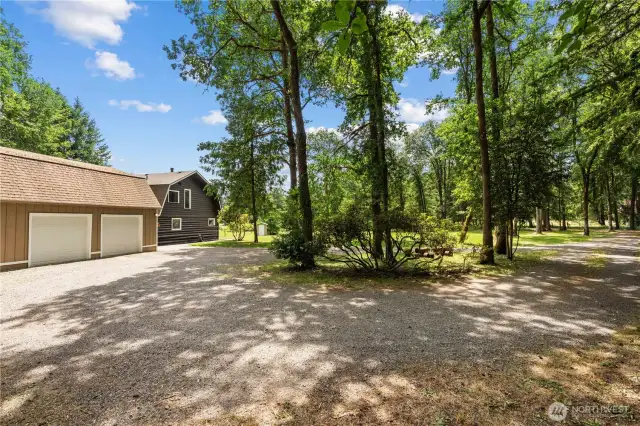 This property features a detached 2-car garage and a charming Pacific Northwest-style log-sided home, all nestled on nearly 10 acres of private forested land. The extended gravel driveway offers ample RV parking, toy storage, and easy access to both the garage and the home’s rear entry. With a 5-bay metal shop also on the property, this is a dream setup for buyers looking for a home with shop space in Washington, or anyone needing room for tools, equipment, or home-based business needs. Ideal for those searching for a rural home with garage and workshop or a multifunctional property with acreage.