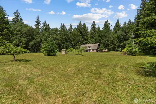 Private Retreat with Home Nestled Among the Trees  This peaceful scene captures the heart of what makes this Rochester property so special—privacy, space & nature in harmony. With the home tucked gently behind a veil of evergreens, this image showcases the unmatched seclusion offered across nearly 10 acres. Enjoy the feel of a hidden getaway while still having open lawn space for play, gardening, or future additions. A true Pacific Northwest retreat where natural beauty surrounds you in every direction.