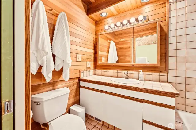 This cozy primary bath has warmth and style with the wood planking!