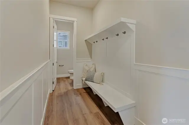 Entering this home from the garage area is also easy and inviting with this custom installed bench seating, coat hook and wainscotting plus a conveniently located half bathroom