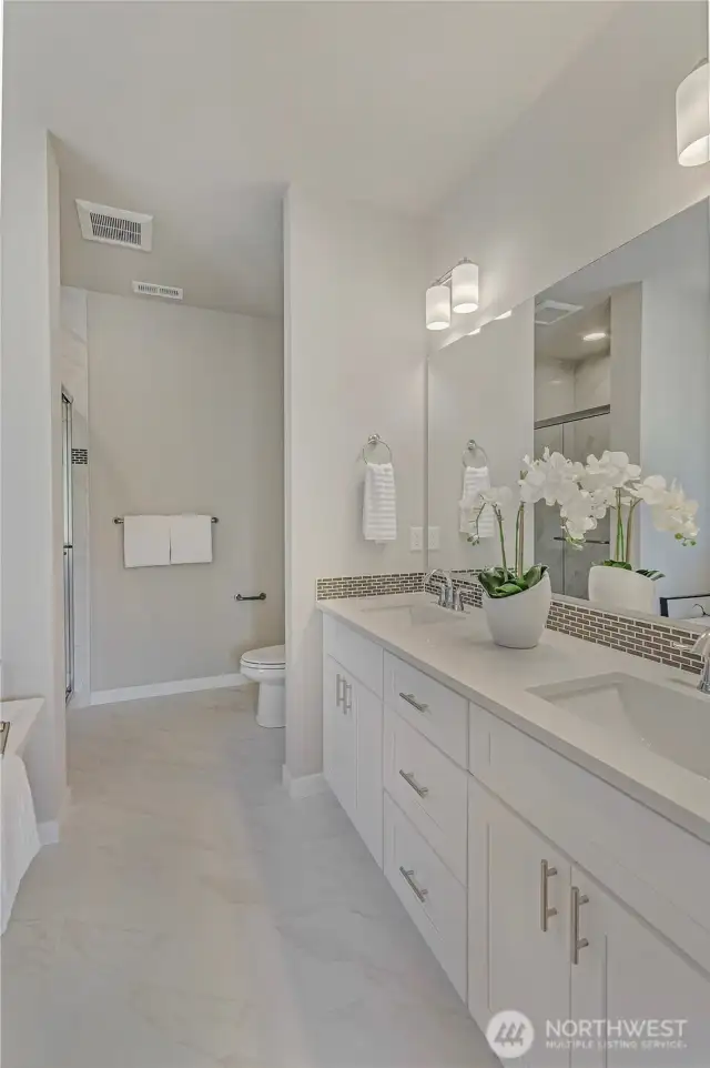 A primary bathroom that incorporates efficient, partitioned areas with custom tile and trim accents