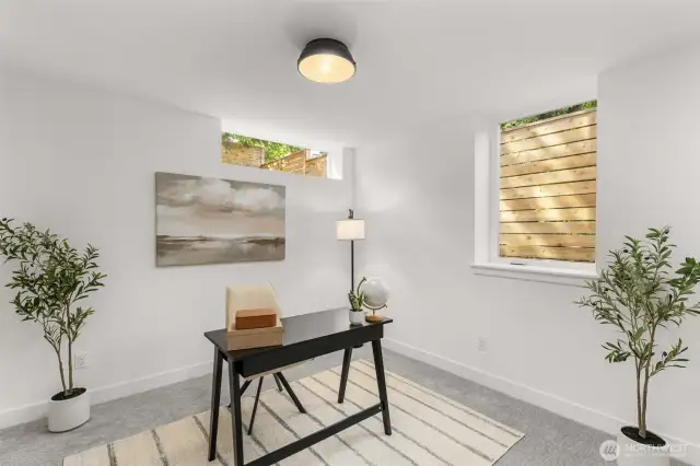 Secondary bedroom or office with large windows and a flexible, comfortable layout.