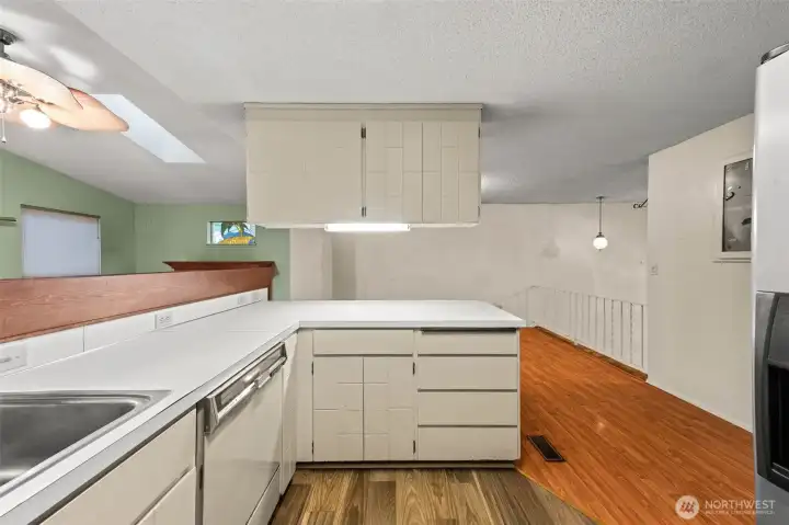 Additional view of the kitchen with the eating area in front and the sunroom to the left.