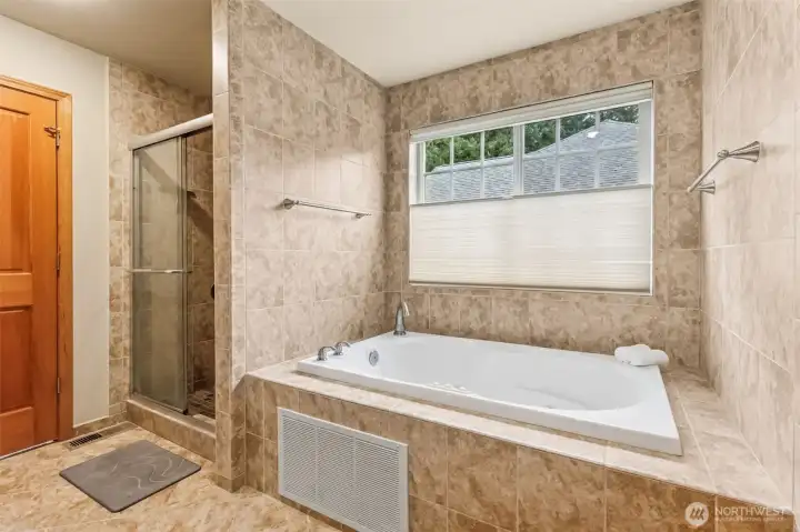Now we’re getting into full spa territory. The walk-in tile shower is clean and easy, and right next to it the jetted tub is basically calling your name after a long day. That big window above the tub brings in great light, and the top down bottom up blinds let you dial in privacy exactly how you want it.
