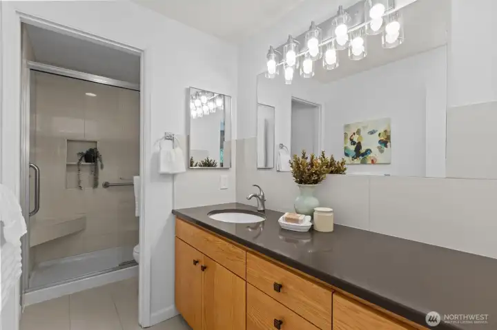 Full bathroom with modern counter updates and step in shower.