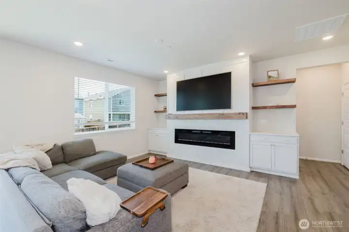 Living room boasts large, built-in electric fireplace with storage cabinets on either side and floating shelves above. Living room boasts large, built-in electric fireplace with storage cabinets on either side and floating shelves above.
