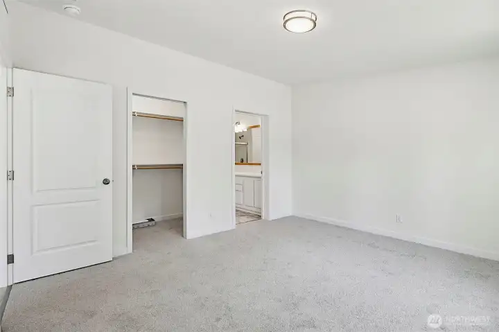 Primary bedroom with walk-in closet and new carpet. Primary bedroom with walk-in closet and new carpet.