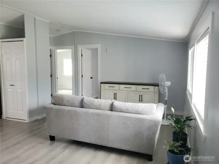 Another Picture of the Huge Living Room Front the Front Entry Door showing New Interior Paint, White Painted Trim and the New Vinyl Plank Flooring.