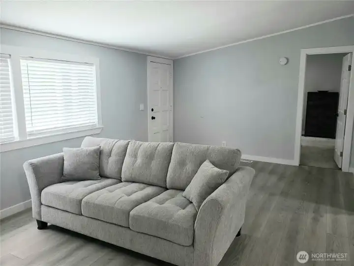 A Picture of the Huge Living Room Front the Primary Master Bedroom showing New Interior Paint, White Painted Trim and the New Vinyl Plank Flooring Looking at the Front Door. A Picture of the Huge Living Room Front the Primary Master Bedroom showing New Interior Paint, White Painted Trim and the New Vinyl Plank Flooring Looking at the Front Door.
