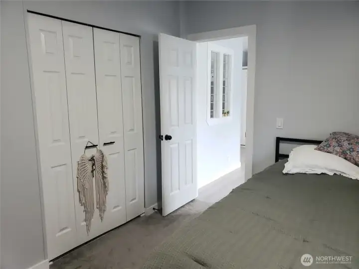 A Different Picture of the Large Primary Master Bedroom showing New 6 Panel Doors, Interior Paint, White Painted Trim and the New Carpet Flooring Looking at the Walk In Closet.