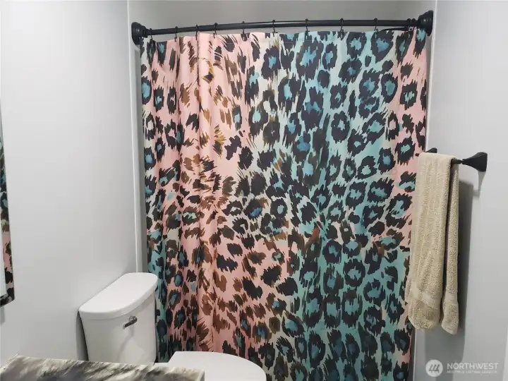 A Picture of the Large Main Guest Bathroom showing New Sink, Faucet, Countertop, Lighted Vanity Mirror, Tub/Shower, Interior Paint, White Painted Trim, New Vinyl Plank Flooring.