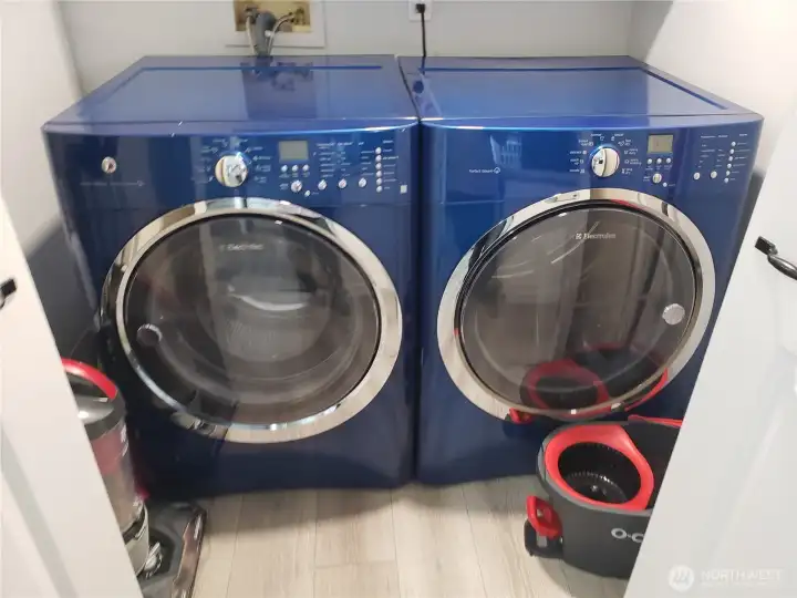 A Picture of the Utility Room with Newer Vinyl Plank Flooring, Paint, Trim, and Washer and Dryer.