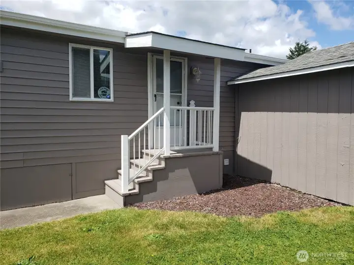 Another Picture of the Large Pet Friendly Fenced Backyard with Easy Care Landscaping Showing the Covered Back Porch.