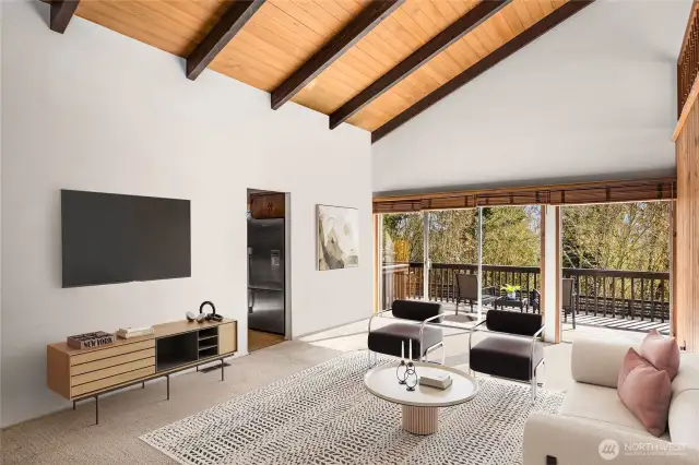 Soaring beamed ceilings create a sense of grandeur, while a dramatic wall of windows floods the space with natural light and offers breathtaking views of the expansive, lush park.