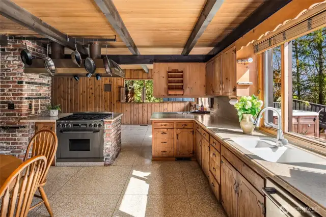 The kitchen is bathed in natural light, seamlessly flowing into the living space and featuring elegant terrazzo floors for a stylish and timeless touch.