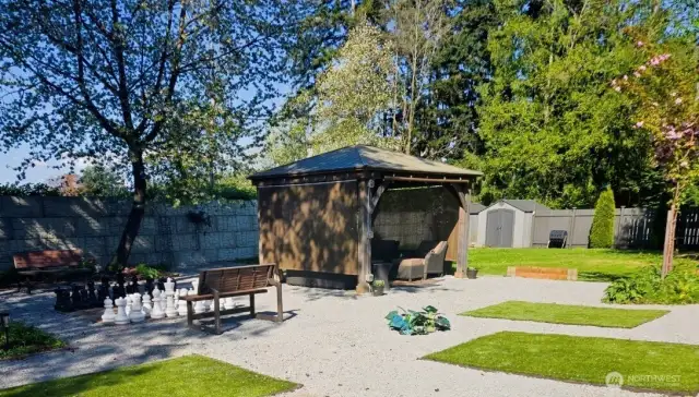 daytime scene of shared park. Building is to the right on the other side of each private backyard.