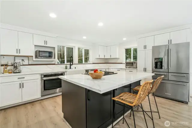 Huge island kitchen with quartz, stainless appliances and views to the backyard!