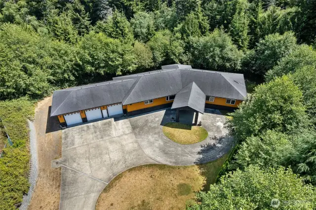 Enjoy the serene and private setting on 2/3 of an acre, two parcels, two separate attached garages with additional workshop space. Not only can you fit 6+ vehicles, but the lower garage is tall enough to function as an RV bay.