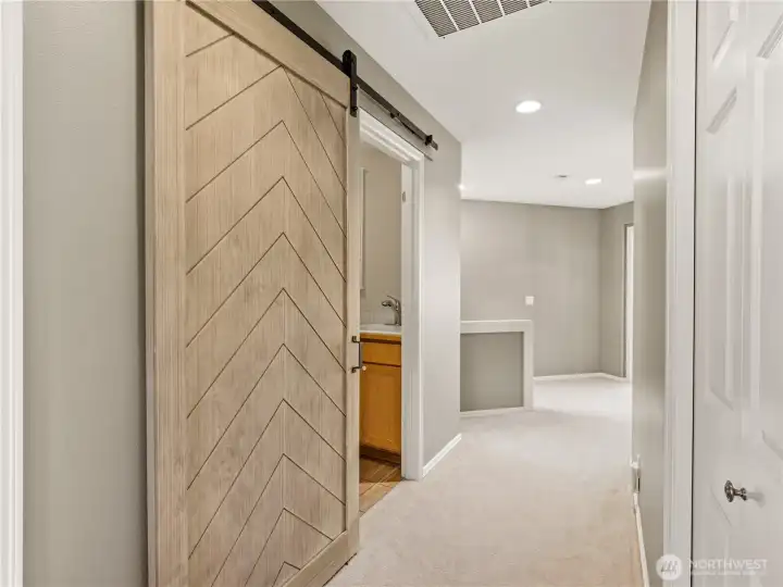 This stunning, oversized chevron-patterned barn door serves as a functional piece of art