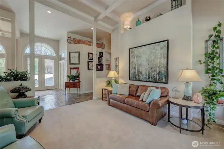 Spacious living room with 16-foot ceilings, abundant natural light, propane fireplace, and open flow perfect for entertaining.