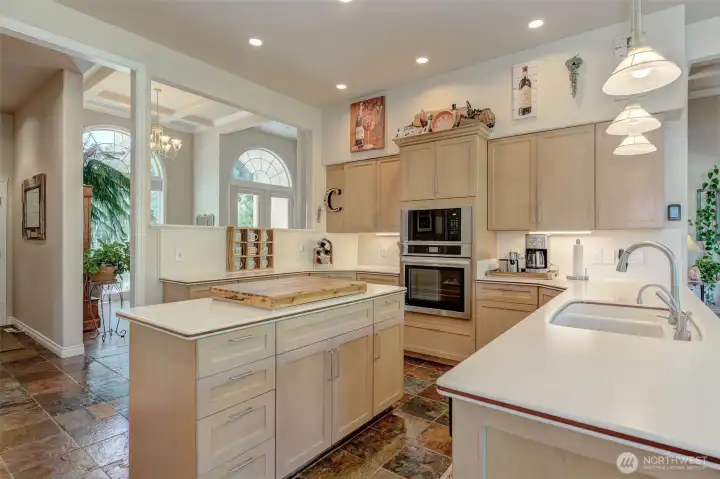 Well-appointed kitchen with Corian countertops, stainless steel appliances, pantry, and updated lighting.