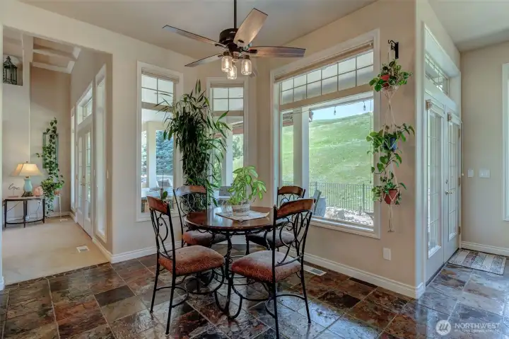 Bright breakfast nook with ceiling fan and views of the backyard, perfect for casual dining.