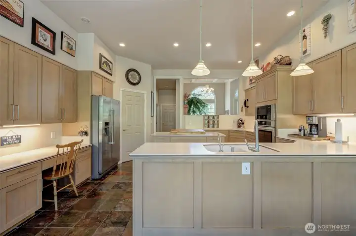 Well-appointed kitchen with Corian countertops, stainless steel appliances, pantry, and updated lighting.