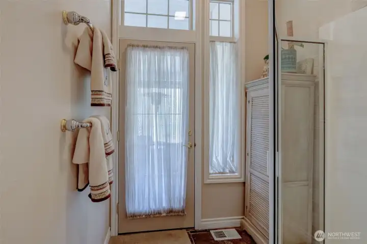 Dual-access main bathroom with direct entry from patio/hot tub and interior hallway, featuring double sinks and private water closet.