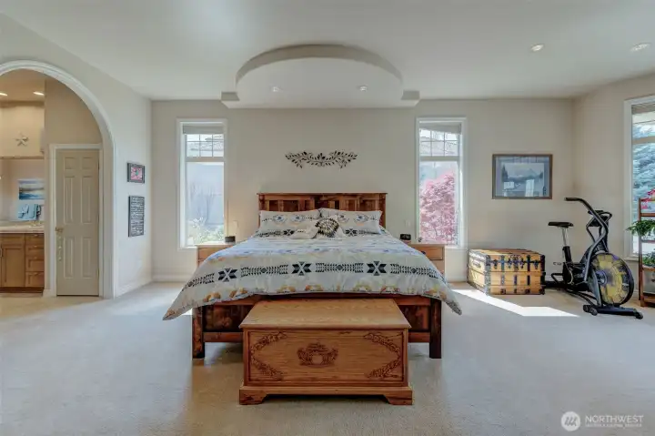 Spacious primary suite with large windows, natural light, and peaceful private setting.Spacious primary suite with large windows, natural light, and peaceful private setting.