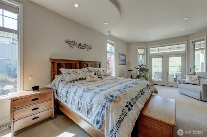 Spacious primary suite with large windows, natural light, and peaceful private setting.