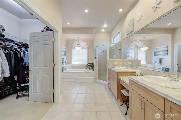 Primary en-suite featuring double sinks, soaking tub, tile walk-in shower, and spa-like jetted tub.