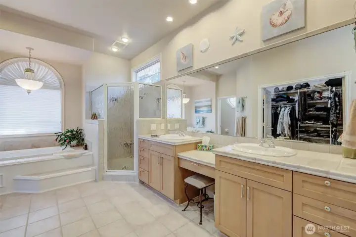Primary en-suite featuring double sinks, soaking tub, tile walk-in shower, and spa-like jetted tub.