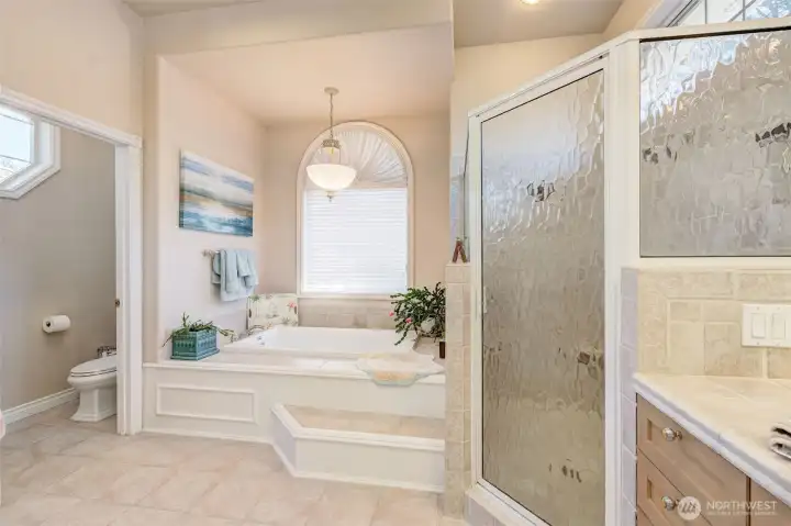 Primary en-suite featuring double sinks, soaking tub, tile walk-in shower, and spa-like jetted tub.