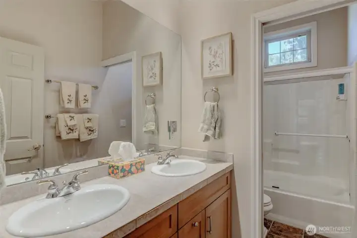 Main bathroom with step-in shower and large soaking tub, ideal for indoor-outdoor living convenience.
